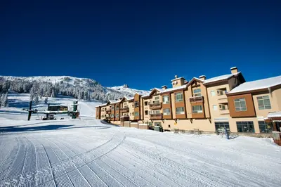 a snow covered street in front of a ski lodge at Kirkwood Mountain Resort by Vail Resorts in Kirkwood