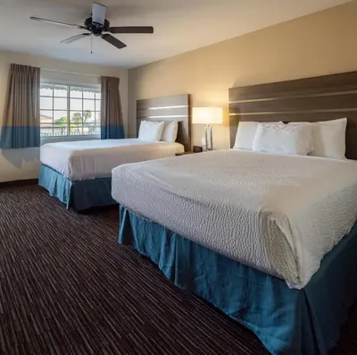 a hotel room with two beds and a window at Rodeway Inn Near University-Gateway to Yosemite in Merced