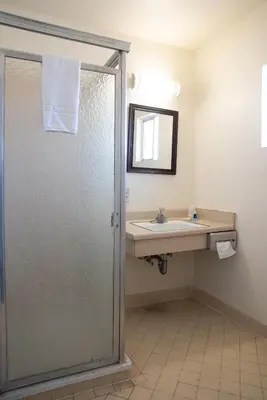 a bathroom with a shower and a sink at Rodeway Inn Near University-Gateway to Yosemite in Merced