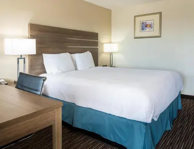a hotel room with a large bed and a desk at Rodeway Inn Near University-Gateway to Yosemite in Merced