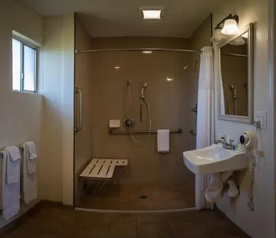 a bathroom with a shower and a sink at Rodeway Inn Near University-Gateway to Yosemite in Merced