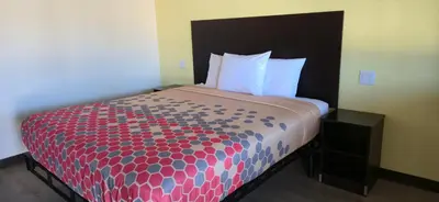 a bed with a red and blue comforter in a room at Grapevine Inn in Lodi