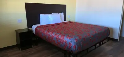 a bedroom with a bed with a red bedspread at Grapevine Inn in Lodi