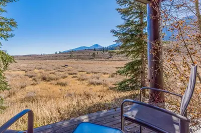 a pair of chairs sitting on a porch looking out at a field at Snowcreek V 820 in Mammoth Lakes