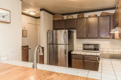 a kitchen with a stainless steel refrigerator and cabinets at Mammoth Ski and Racquet 132 in Mammoth Lakes