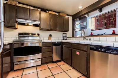 a kitchen with wooden cabinets and stainless steel appliances at Mammoth Ski and Racquet 132 in Mammoth Lakes
