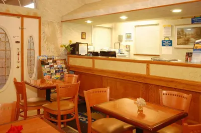 a restaurant with tables and chairs and a counter at Days Inn by Wyndham Bishop in Bishop