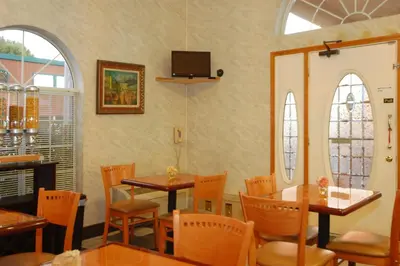 a dining room with tables and chairs and a tv at Days Inn by Wyndham Bishop in Bishop