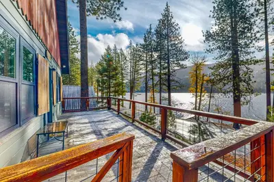 a balcony of a house with a view of the water at Donner Lake Dream Cabin in Donner Lake Village