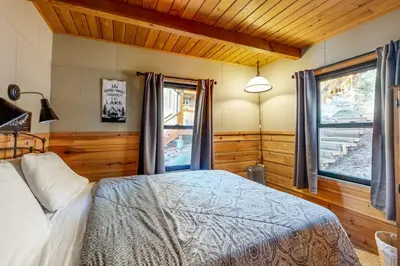 a bedroom with a bed and two windows at Donner Lake Dream Cabin in Donner Lake Village