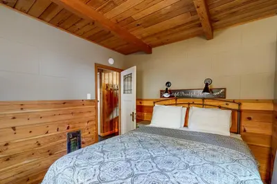 a bedroom with a bed in a room with wooden walls at Donner Lake Dream Cabin in Donner Lake Village