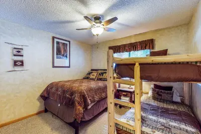 a bedroom with two bunk beds and a ceiling fan at Saxon Creek in Mevers