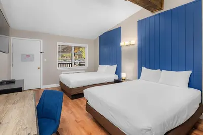a hotel room with two beds and a blue wall at The Inn at Boatworks, Lake Tahoe in Tahoe City