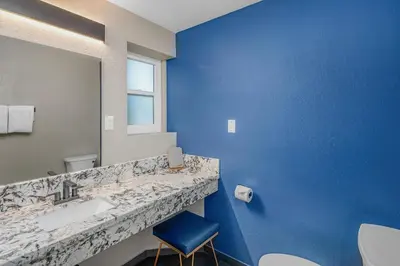 a blue bathroom with a sink and a mirror at The Inn at Boatworks, Lake Tahoe in Tahoe City