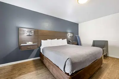 a bedroom with a large bed and a chair at Econo Lodge Inn & Suites Heavenly Village Area in South Lake Tahoe