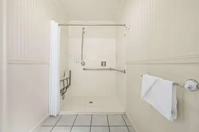 a white bathroom with a shower and towels at Econo Lodge Inn & Suites Heavenly Village Area in South Lake Tahoe