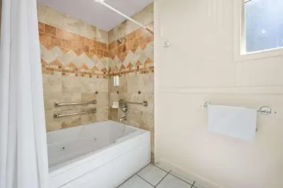 a white bath tub in a bathroom with a window at Econo Lodge Inn & Suites Heavenly Village Area in South Lake Tahoe
