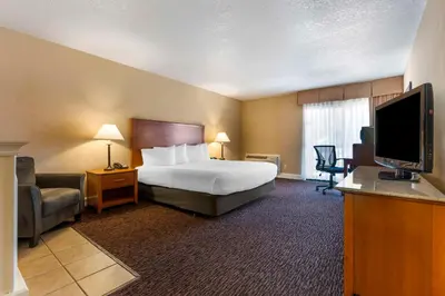 a hotel room with a bed and a flat screen tv at Best Western Plus Placerville Inn in Placerville
