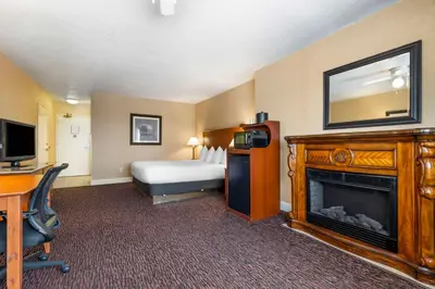 a hotel room with a bed and a fireplace at Best Western Plus Placerville Inn in Placerville