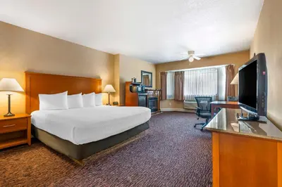a hotel room with a bed and a flat screen tv at Best Western Plus Placerville Inn in Placerville
