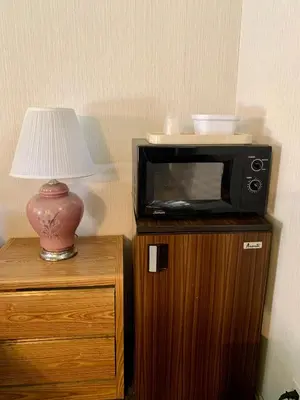 a microwave sitting on top of a wooden cabinet with a lamp at Stevenson’s Inn in Kings Beach