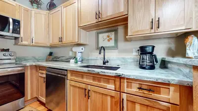 a kitchen with wooden cabinets and a sink at Chateau De Montagne #1 Condo in Mammoth Lakes