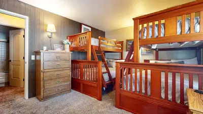 a bedroom with two bunk beds and a staircase at Chateau De Montagne #1 Condo in Mammoth Lakes