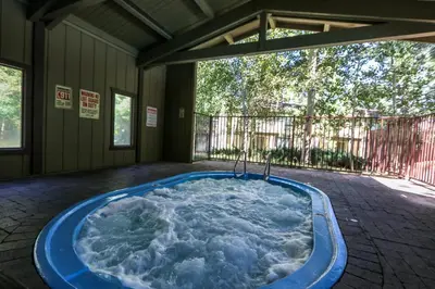 a jacuzzi tub in the middle of a patio at Chateau De Montagne #1 Condo in Mammoth Lakes