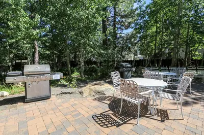a patio with a table and chairs and a grill at Chateau De Montagne #1 Condo in Mammoth Lakes