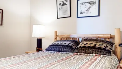 a bedroom with a wooden bed with two pillows at Mammoth West #140 Condo in Mammoth Lakes