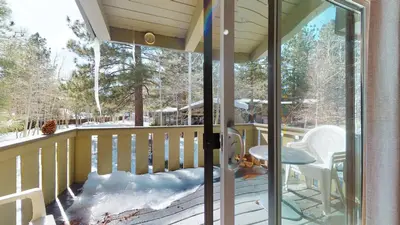 a screened in porch with snow on the deck at Chateau De Montagne #15 Condo in Mammoth Lakes