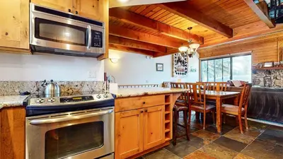 a kitchen with a stove and a dining room at Snowflower #26 Condo in Mammoth Lakes