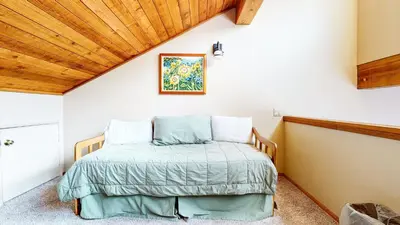 a bed in a room with a wooden ceiling at Snowflower #26 Condo in Mammoth Lakes