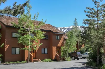 a house with a mountain in the background at Snowflower #26 Condo in Mammoth Lakes