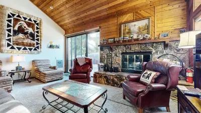a living room with a stone fireplace and leather chairs at Snowflower #26 Condo in Mammoth Lakes