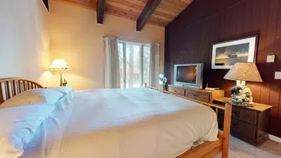 a bedroom with a large bed and a television at Chateau De Montagne #23 Condo in Mammoth Lakes