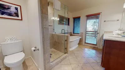 a bathroom with a shower and a toilet and a tub at Bridges Townhome #09 Condo in Mammoth Lakes