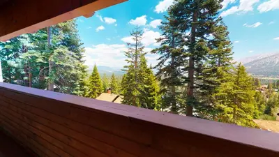 a balcony with a view of trees and mountains at Bridges #105 Condo in Mammoth Lakes