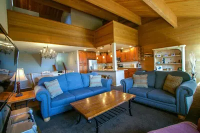 a living room with blue couches and a table at Bridges Townhome #07 Condo in Mammoth Lakes