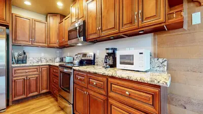 a kitchen with wooden cabinets and a microwave at Bridges Townhome #07 Condo in Mammoth Lakes