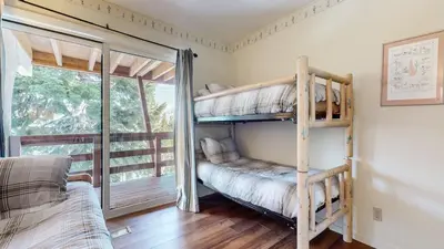 a bedroom with two bunk beds and a balcony at Bridges Townhome #07 Condo in Mammoth Lakes