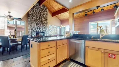 a large kitchen with wooden cabinets and a dining room at Bridges Townhome #13 Condo in Mammoth Lakes