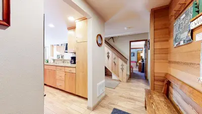 a kitchen with wooden cabinets and a stairway at Sierra Megeve #7 Condo in Mammoth Lakes