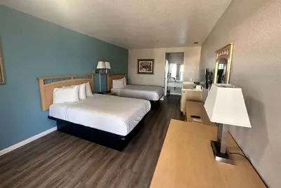 a hotel room with two beds and a lamp at Days Inn by Wyndham Rocklin/Sacramento in Rocklin