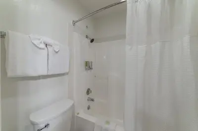a white bathroom with a shower and a toilet at Alpenhof Lodge in Mammoth Lakes