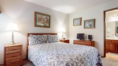 a bedroom with a bed and a tv and a mirror at Snowflower #74 Condo in Mammoth Lakes