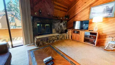 a living room with a fireplace and a television at Snowflower #74 Condo in Mammoth Lakes