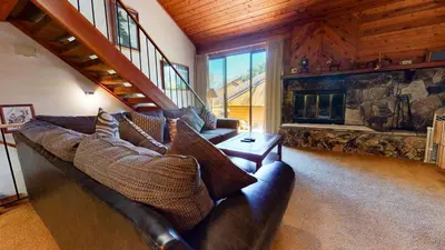 a living room with a leather couch and a fireplace at Snowflower #74 Condo in Mammoth Lakes