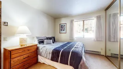 a bedroom with a bed with a dresser and a window at Snowflower #68 Condo in Mammoth Lakes