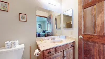 a bathroom with a sink and a toilet and a mirror at Snowflower #68 Condo in Mammoth Lakes
